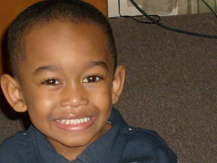 TJ as a young child with a big, bright smile