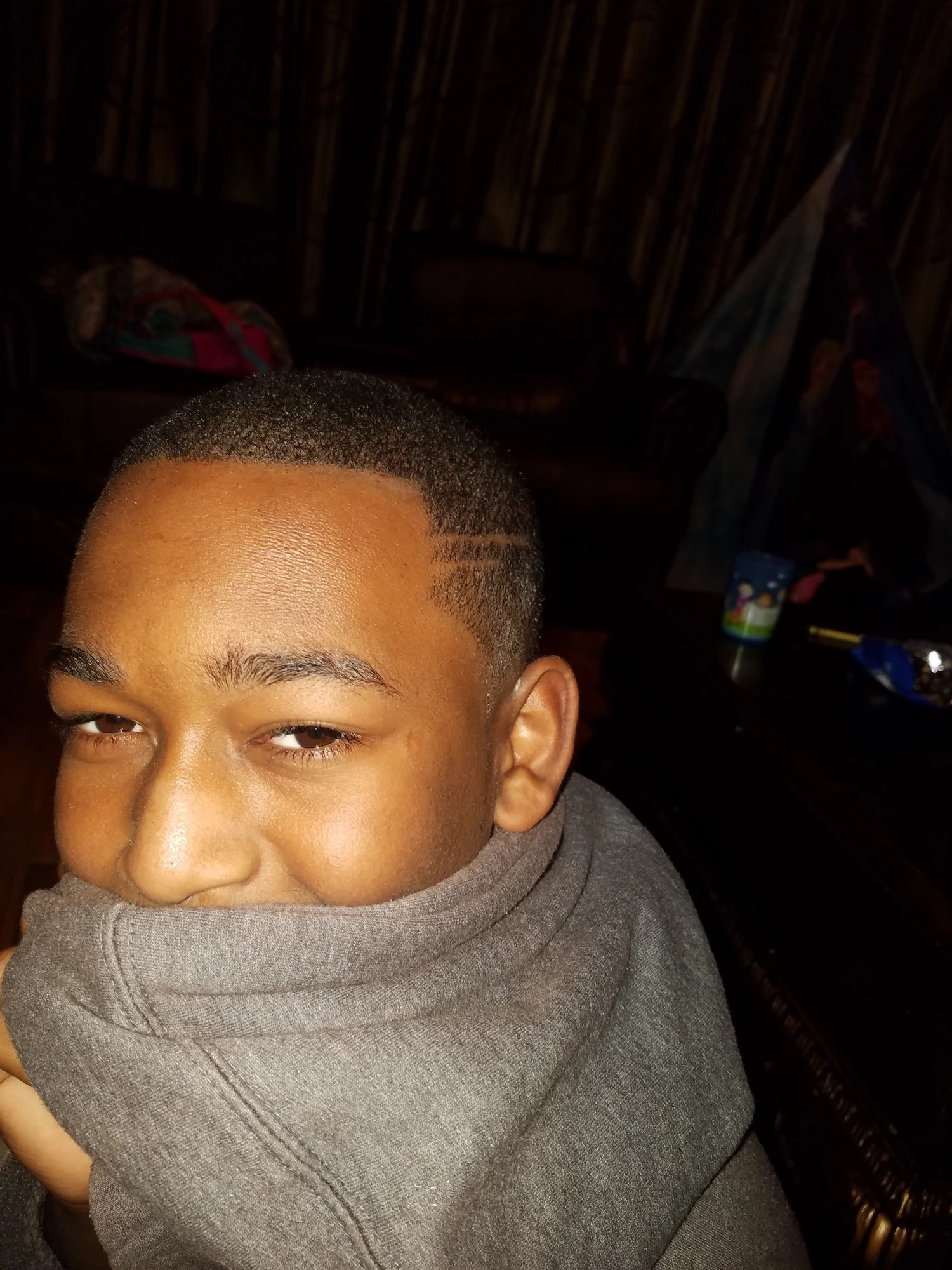 TJ lying back in a gray shirt, smiling at the camera
