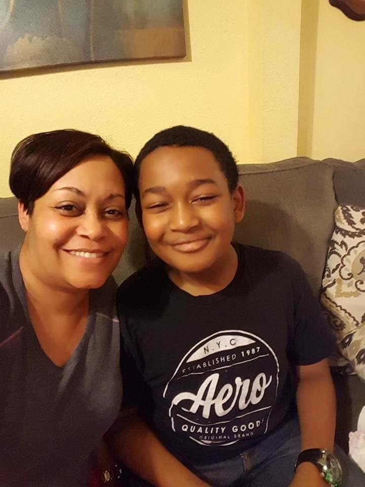 TJ and his mother sitting close together on a couch, both smiling